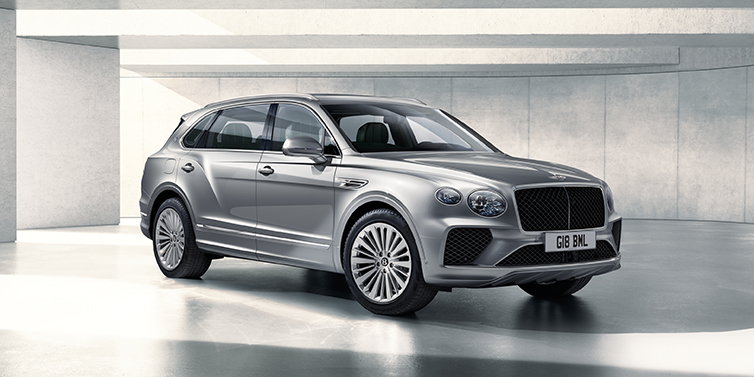 Bentley Lugano Bentley Bentayga Extended Wheelbase SUV front three quarter in Moonbeam paint with a grey background